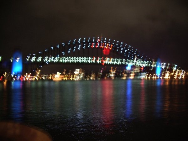 View of the Sydney Harbour Bridge from the Opera House, with lights from NYE 2005 still on display. January 17, 2005, with Tori.