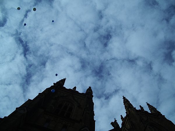 Balloons floating upwards (background) above the cathedral (mid-background)