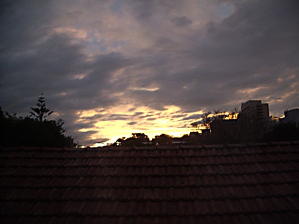 Sunset with a terracotta roof in foreground.