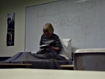 Mrs. Christie lying in a makeshift 'bed' reciting a poem
