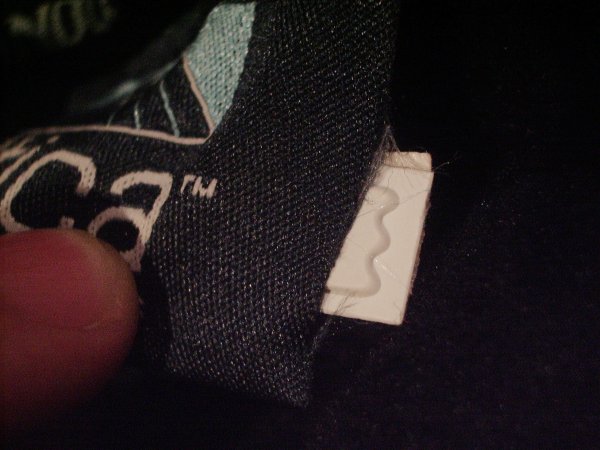 The tag comes out of the slit in the side of the tag