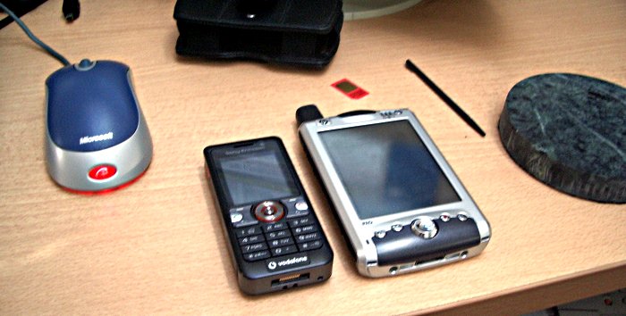 Sony Ericsson V630i next to an iPaq